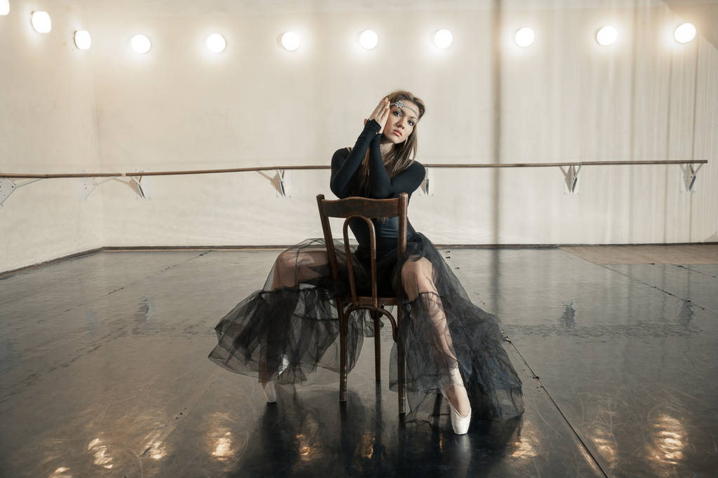 Dançarino de balé contemporâneo em uma cadeira de madeira em uma repetição
 - Foto, Imagem