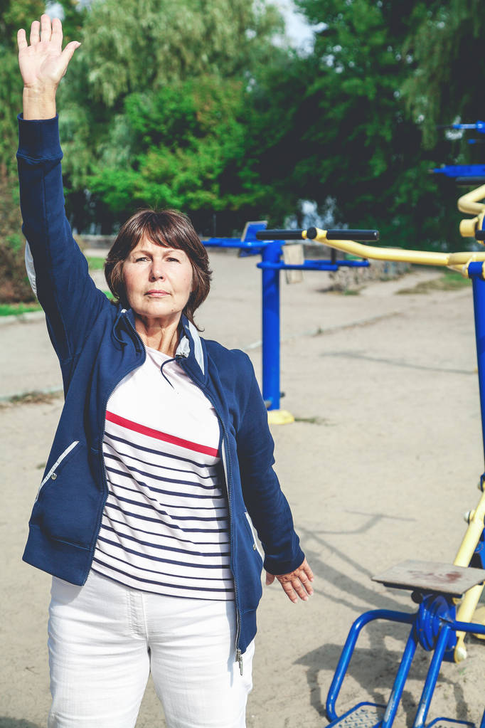 Mujer jubilada linda realiza ejercicios gimnásticos en la calle
 - Foto, imagen