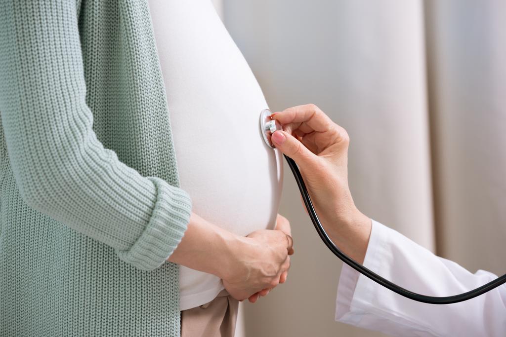 妊娠中の女性の医者リスニング腹  - 写真・画像