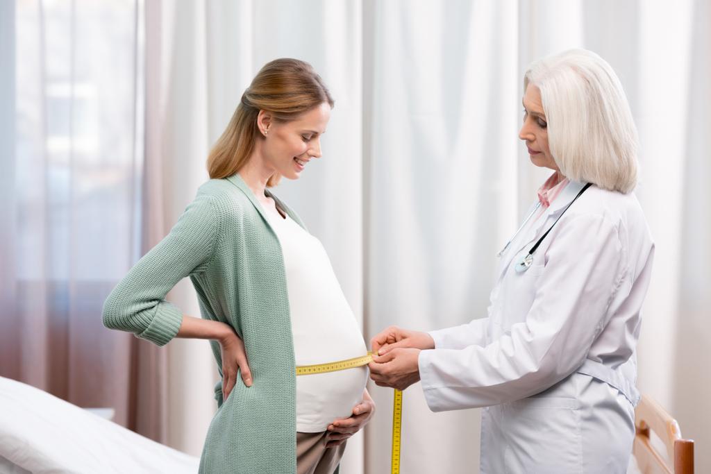 Medico che misura la pancia della donna incinta
 - Foto, immagini
