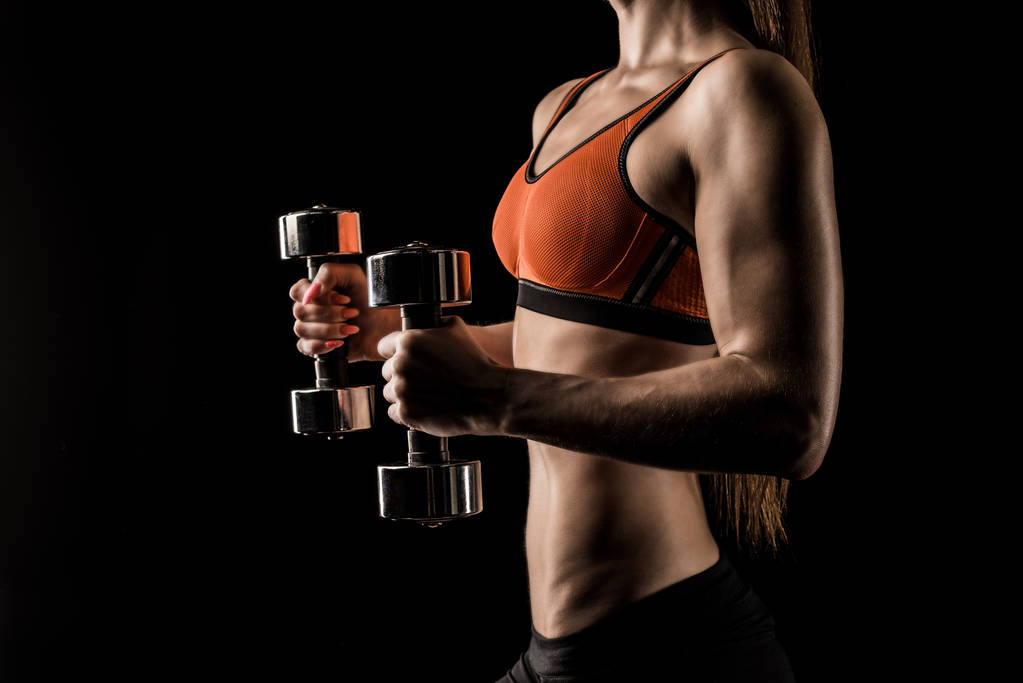 Sportswoman exercising with dumbbells  - Photo, Image