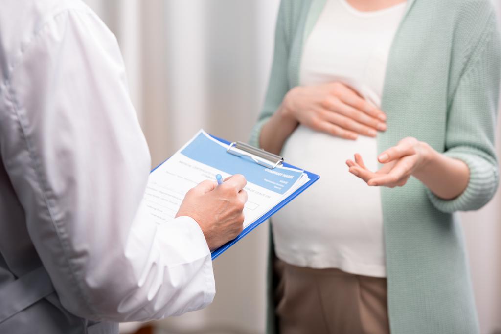 γιατρός με έγκυο γυναίκα κατά τη διάρκεια της διαβούλευσης - Φωτογραφία, εικόνα