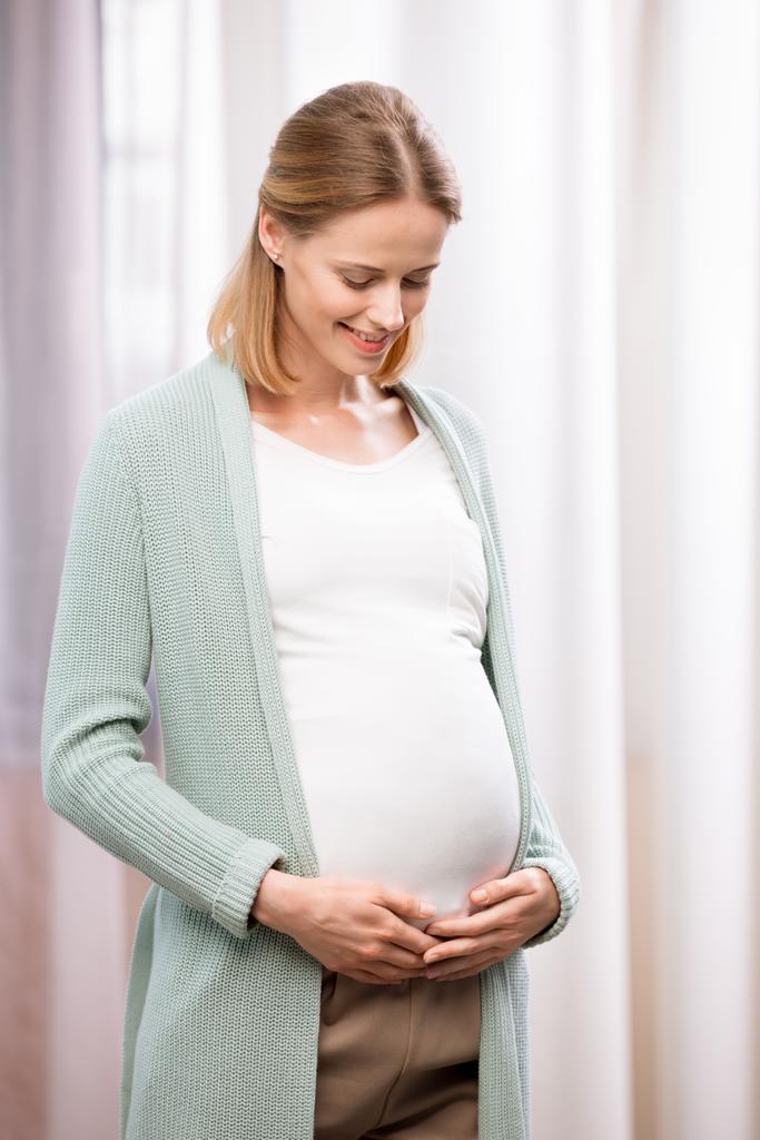 heureuse femme enceinte tenant l'estomac
 - Photo, image