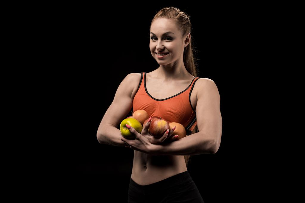 smiling caucasian sportswoman holding apples - Photo, Image