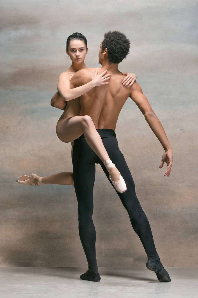 Ein paar Balletttänzer posieren vor grauem Hintergrund - Foto, Bild