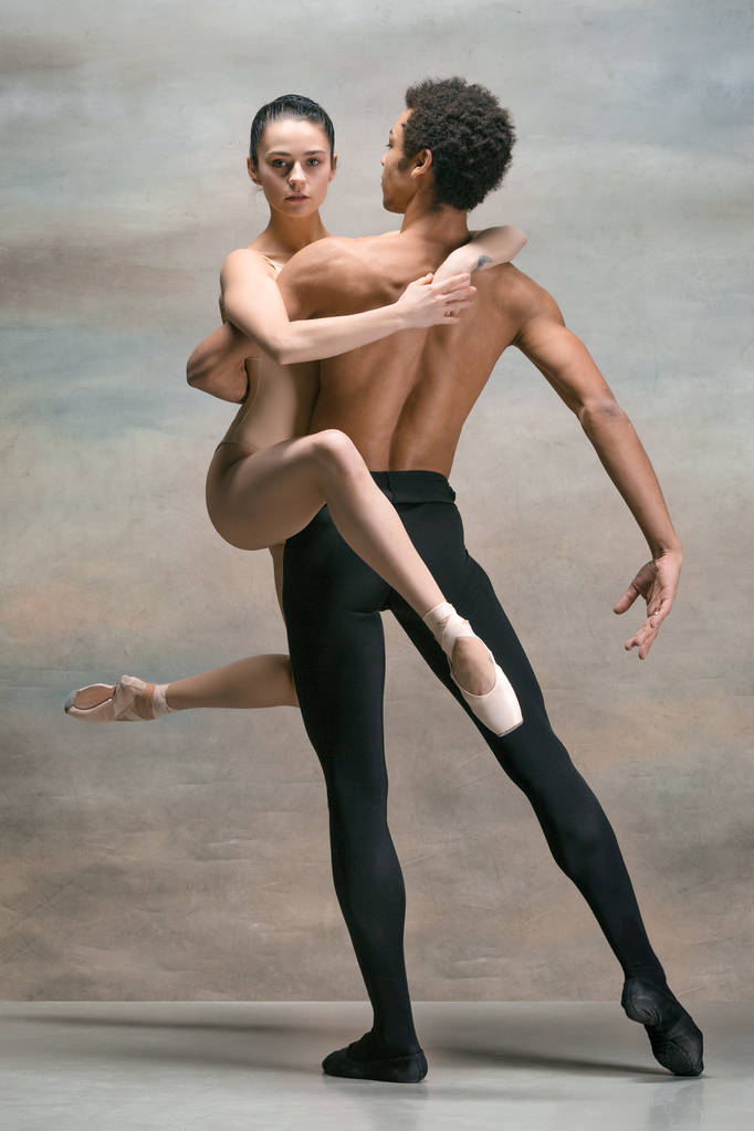 Pareja de bailarines de ballet posando sobre fondo gris
 - Foto, Imagen