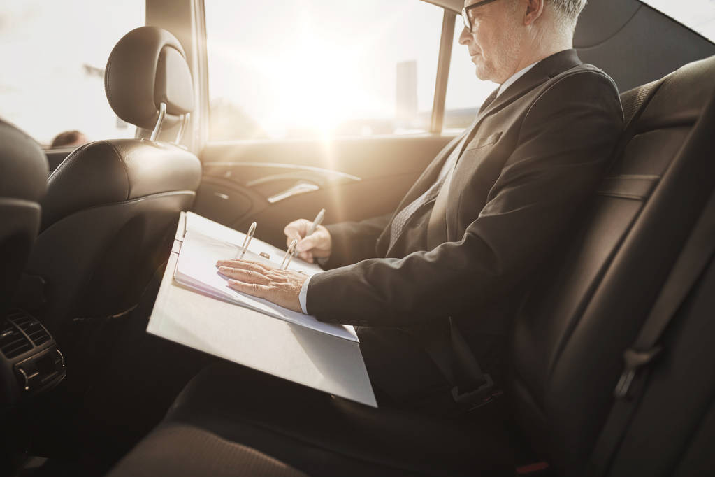 ανώτερος επιχειρηματίας με χαρτιά οδήγηση σε αυτοκίνητο - Φωτογραφία, εικόνα