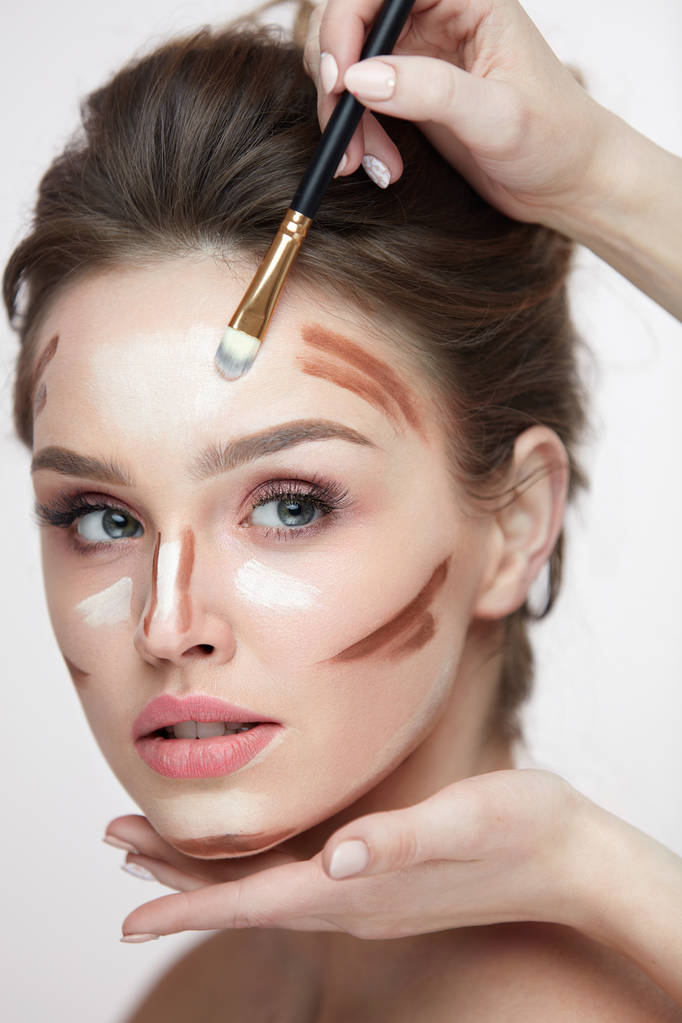 Maquiagem de beleza. Mulher bonita aplicando linhas de contorno no rosto
 - Foto, Imagem