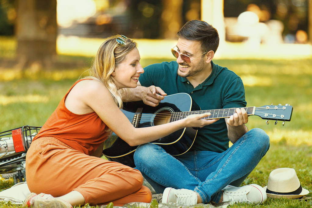 Pareja de amor disfrutando de la guitarra en el parque
 - Foto, imagen