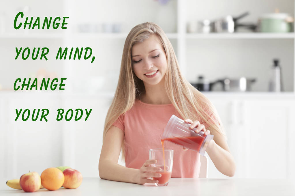 Концепція мотивації втрати ваги. Молода жінка поливає свіжий сік на кухні. Текст CHANGE YOUR BODY, CHANGE YOUR MIND на фоні
 - Фото, зображення