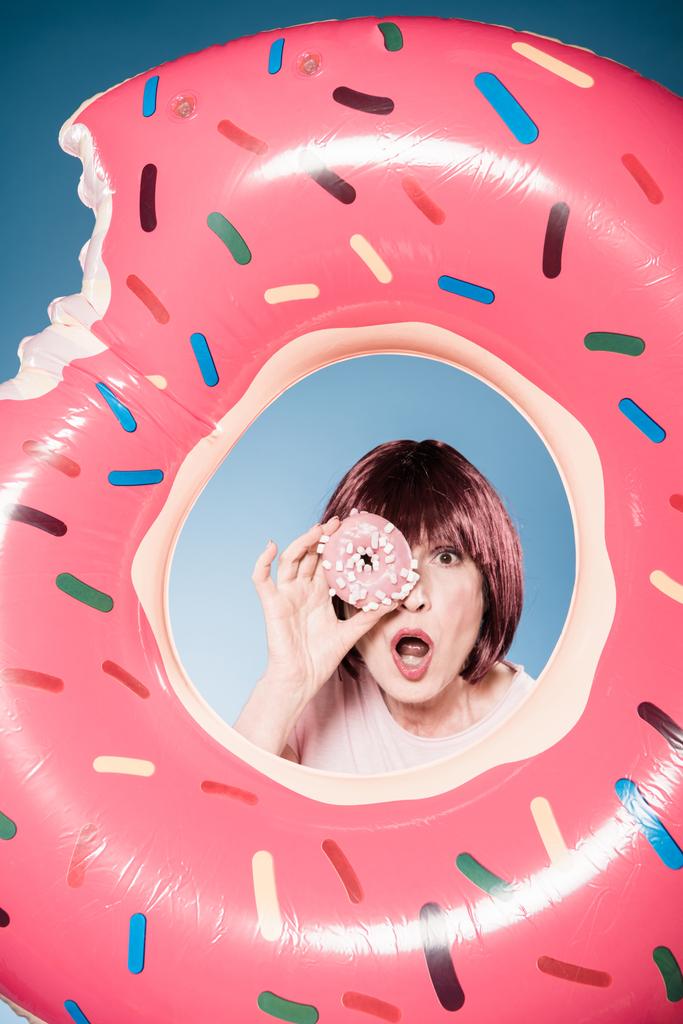mujer sosteniendo donut delante del ojo
 - Foto, imagen