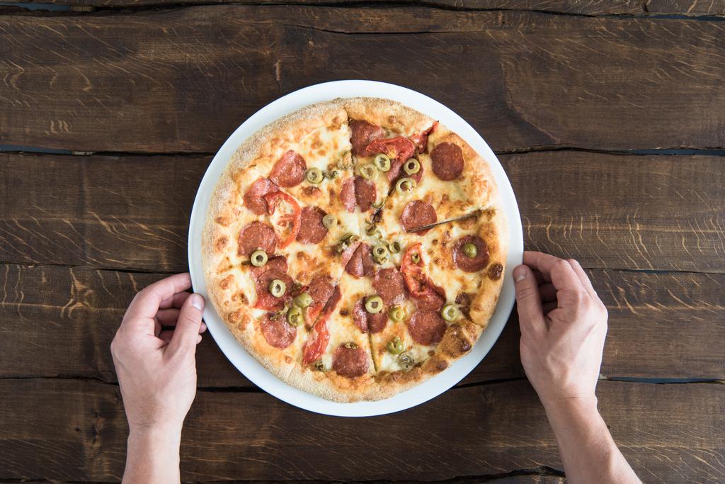 людина їсть піци
  - Фото, зображення