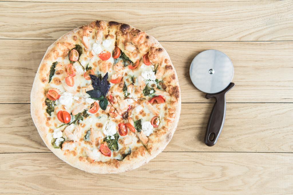 Italiaanse pizza met kotterstag op houten tafelblad - Foto, afbeelding