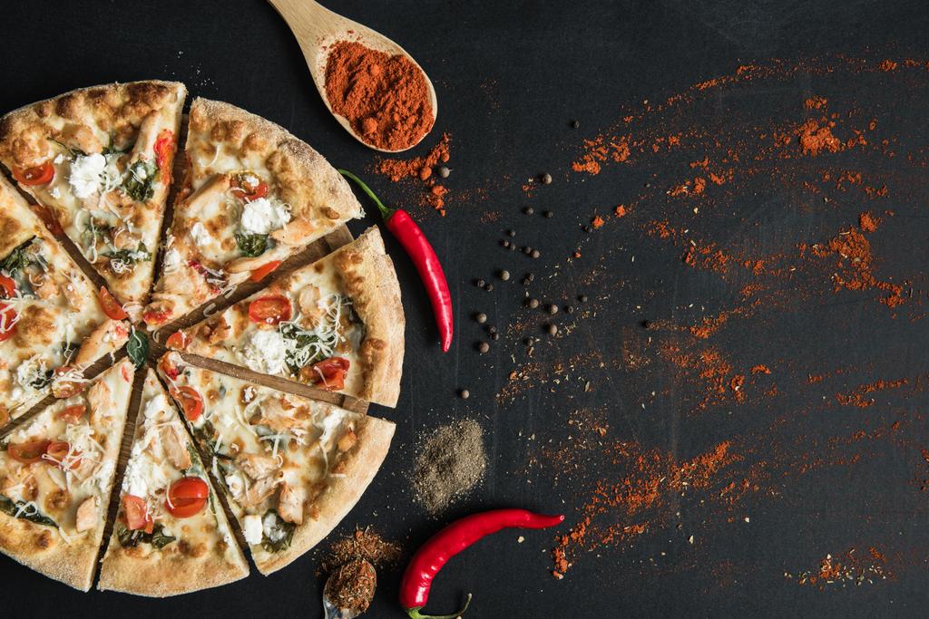 Italienische Pizza in Scheiben geschnitten mit Gewürzen und Kräutern - Foto, Bild