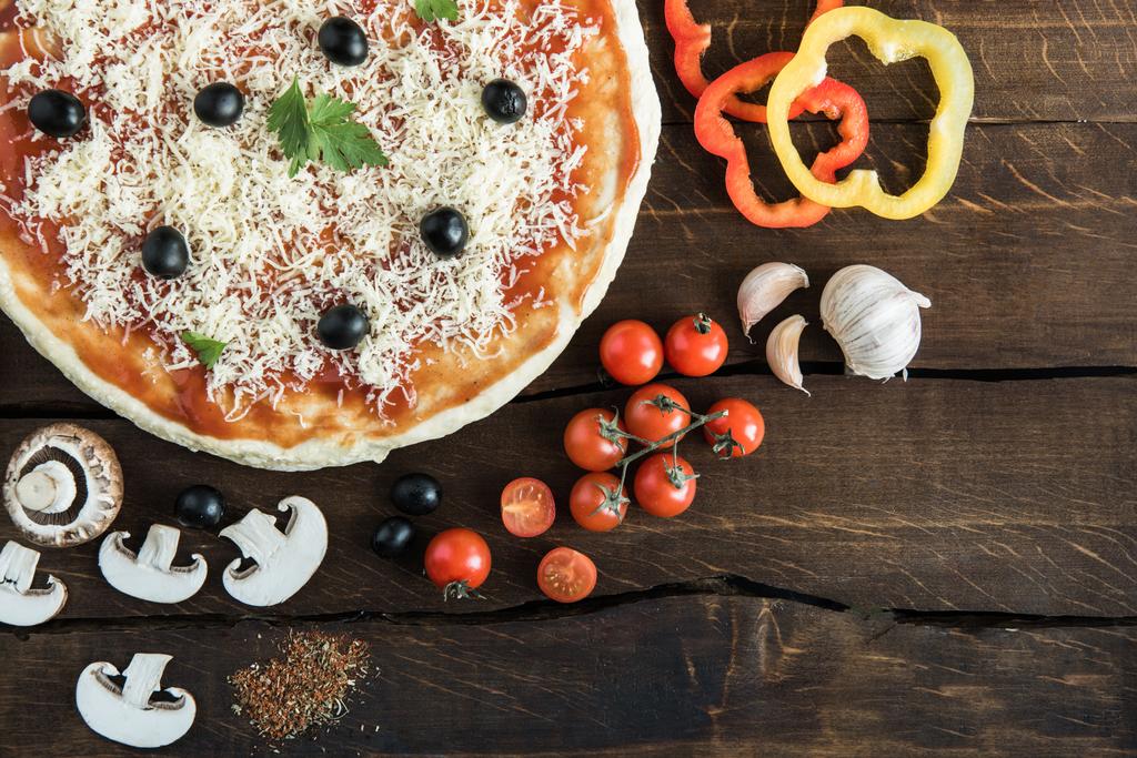 Pizza mit Käse und Gemüse auf Holztisch - Foto, Bild