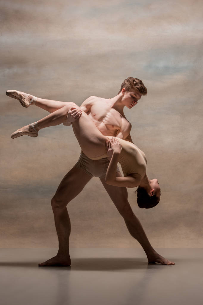 Pareja de bailarines de ballet posando sobre fondo gris
 - Foto, imagen