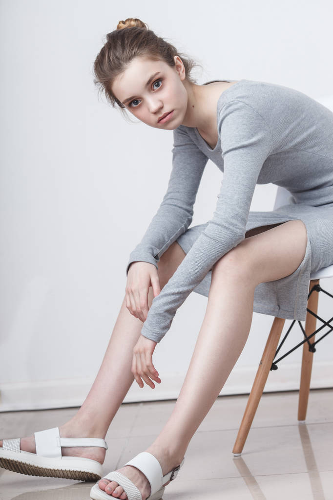 молода модель дівчини-підлітка, що сидить на стільці
 - Фото, зображення