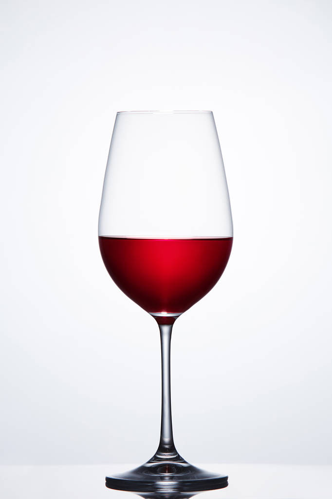 Punaviini hauras puhdas viinilasi seisoo valoa vasten taivasta heijastus
. - Valokuva, kuva