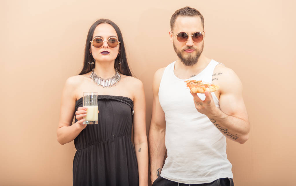 ein Mädchen trinkt Milch, und ein Mann isst Pizza - Foto, Bild