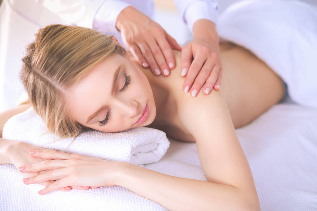 Jeune femme allongée sur une table de massage, relaxante les yeux fermés
 - Photo, image