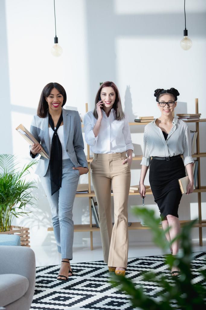 jovens empresárias multiétnicas caminhando no escritório
 - Foto, Imagem