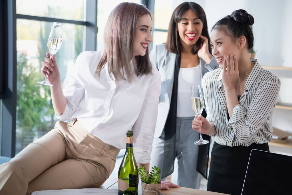 mulheres de negócios multiétnicas sorrindo e bebendo champanhe
 - Foto, Imagem