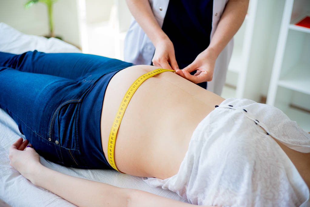 Médecin vérifiant femme enceinte avec ruban à mesurer
 - Photo, image