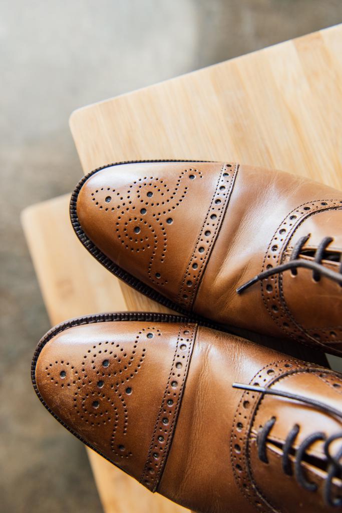 zapatos oxford marrón en taburete de madera
 - Foto, imagen