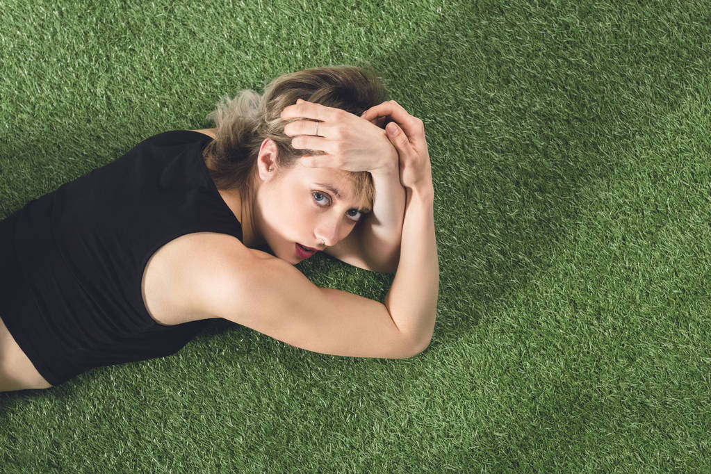 стомлена дівчина розслабляється на траві
 - Фото, зображення