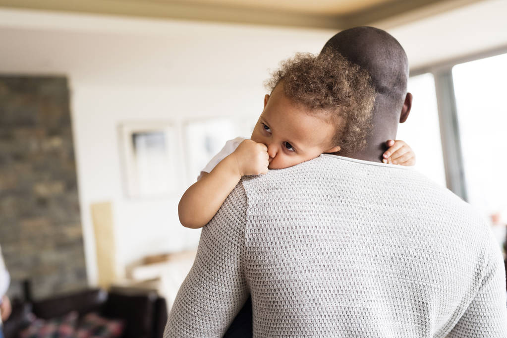 Irreconocible padre afroamericano sosteniendo a su hijita
 - Foto, imagen