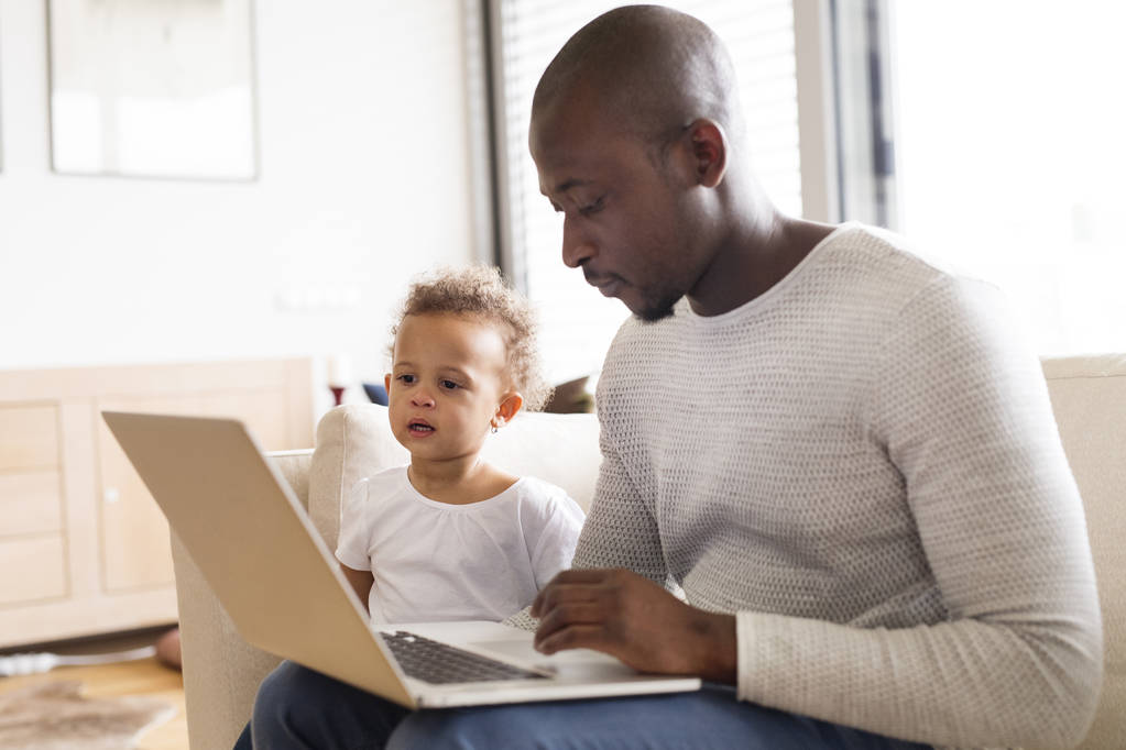 Afroamerikkalainen isä, jolla on pieni tytär kotona kannettava tietokone
. - Valokuva, kuva
