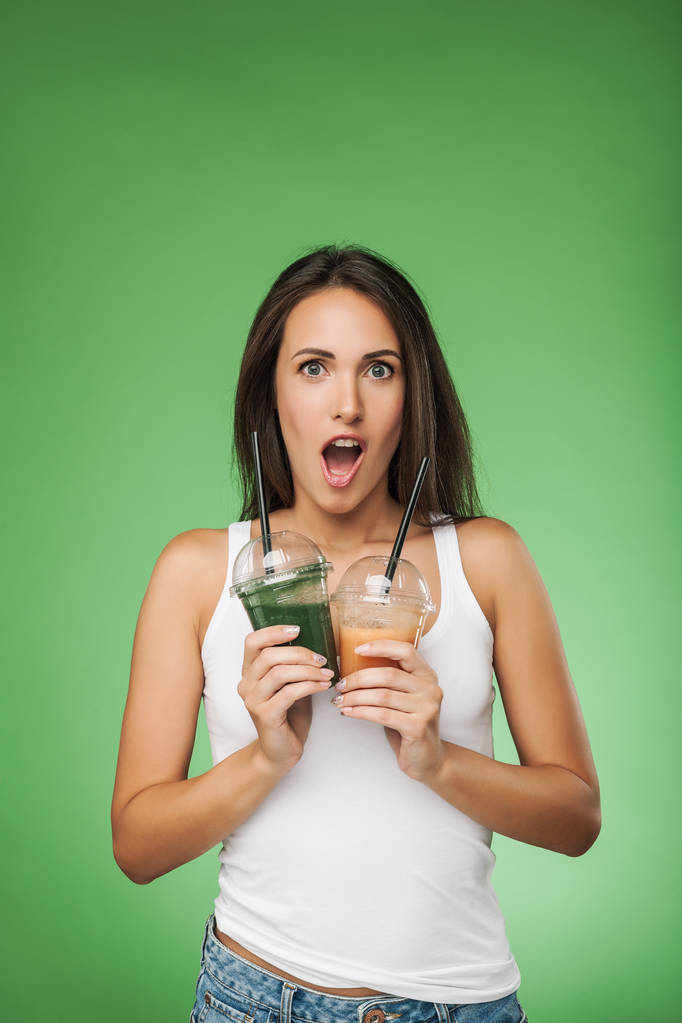 Joven mujer sorprendida sosteniendo smoothie
 - Foto, Imagen