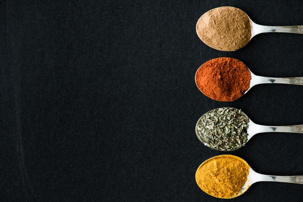 various spices and herbs in metal spoons - Photo, Image