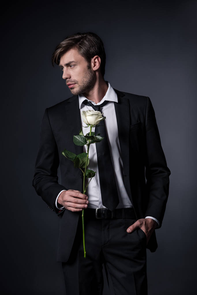 людина в офіційному носінні тримає троянду
 - Фото, зображення