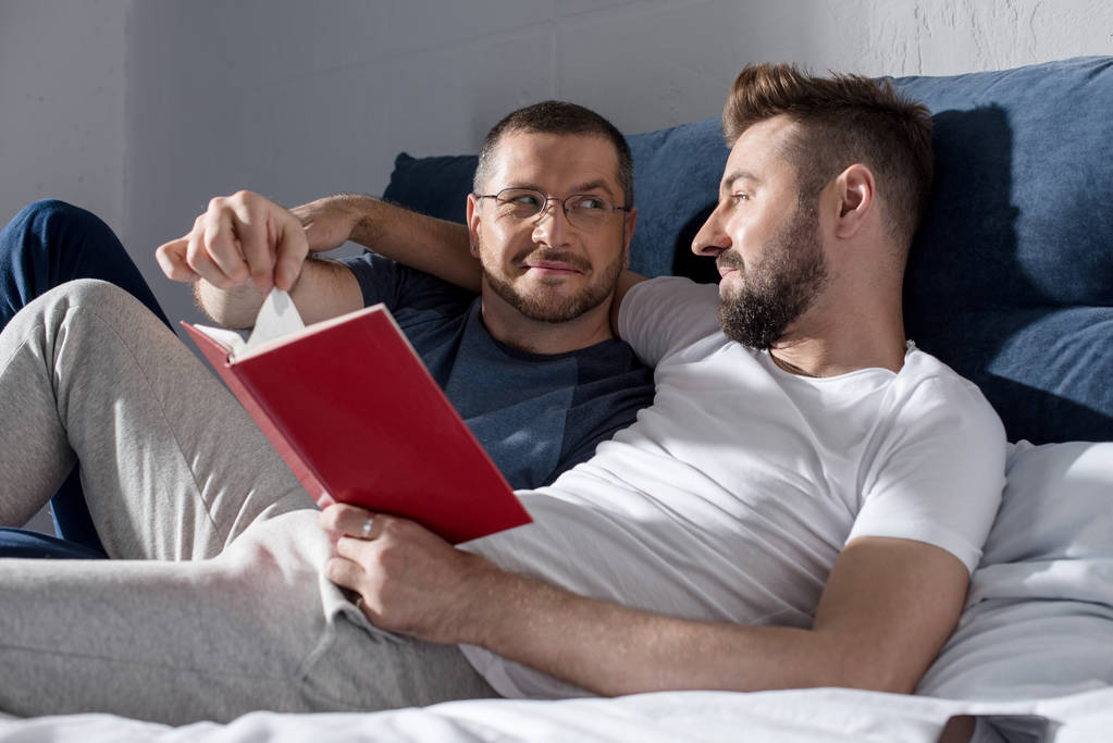 Гомосексуальная пара читает книгу
  - Фото, изображение