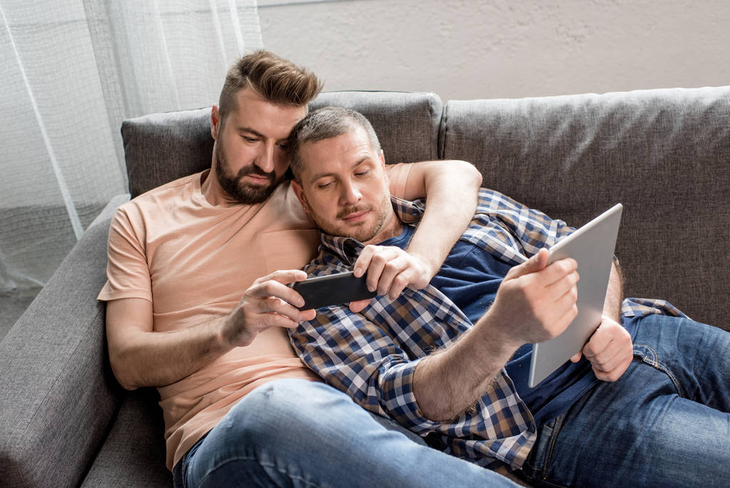 Ομοφυλόφιλο ζευγάρι χρησιμοποιώντας ψηφιακές συσκευές - Φωτογραφία, εικόνα