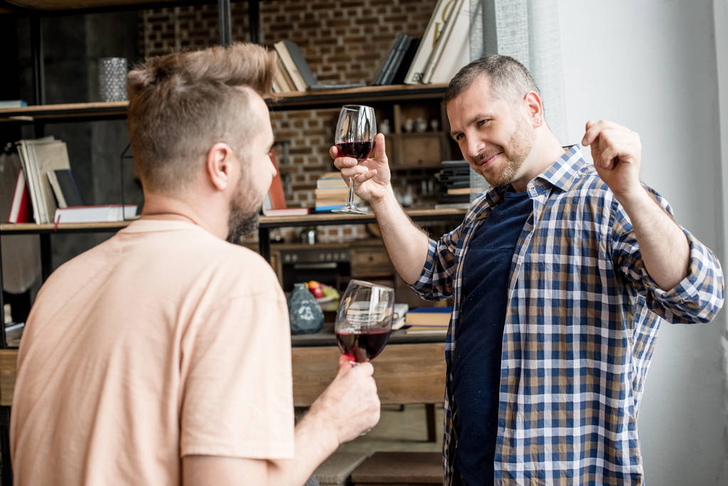 homoseksueel paar praten en drinken van wijn - Foto, afbeelding