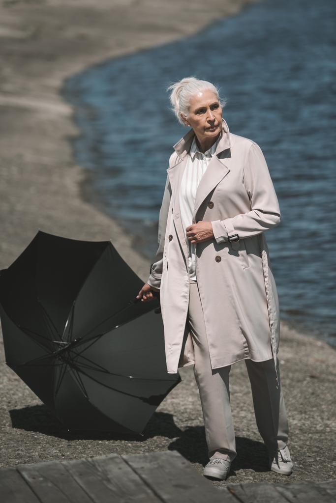 Ανώτερος γυναίκα με ομπρέλα  - Φωτογραφία, εικόνα