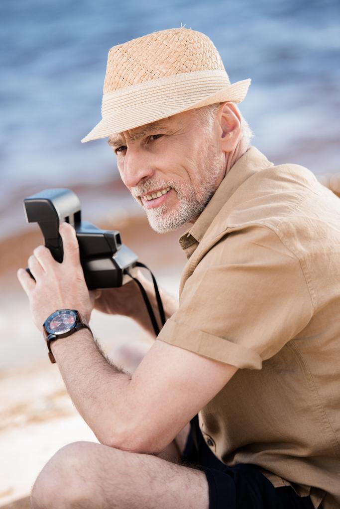 Senior man met instant camera  - Foto, afbeelding