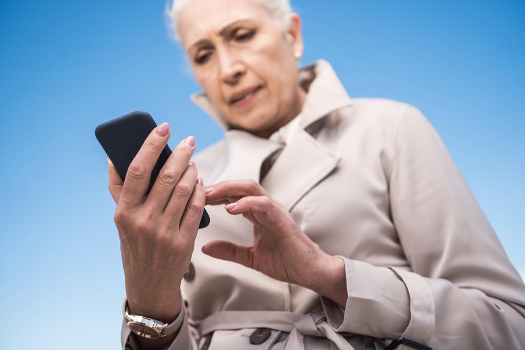 mulher de cabelos grisalhos usando smartphone
 - Foto, Imagem