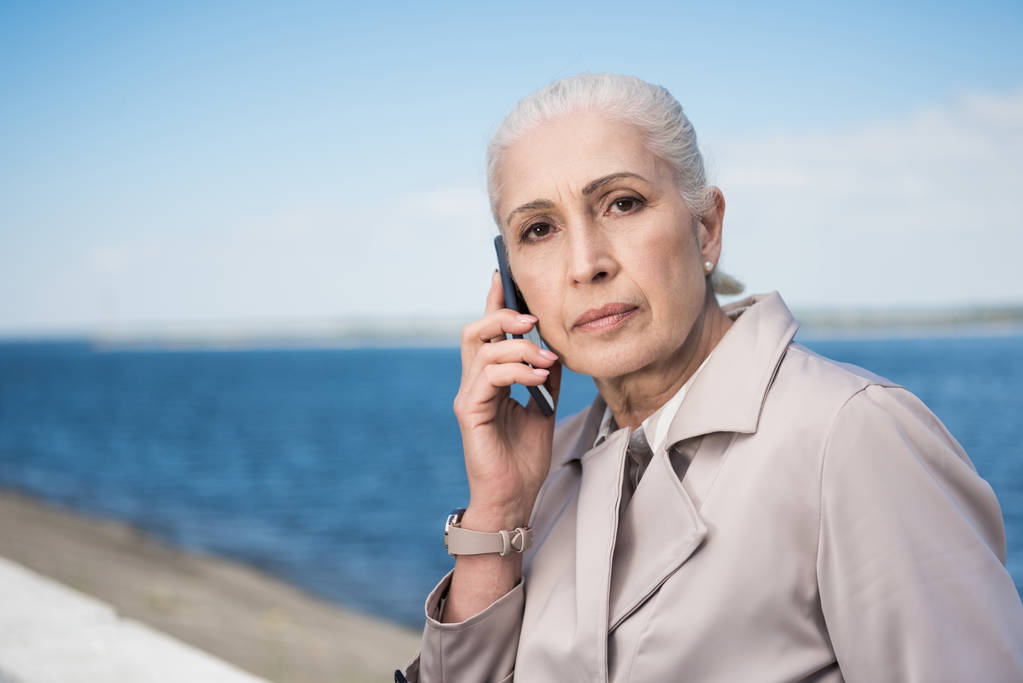 mujer mayor hablando en el smartphone en el muelle
 - Foto, Imagen