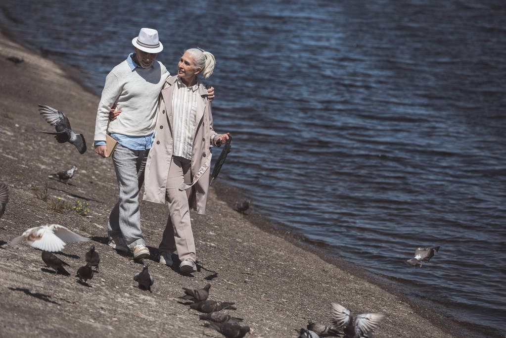 pareja de ancianos caminando en la orilla del río
 - Foto, Imagen