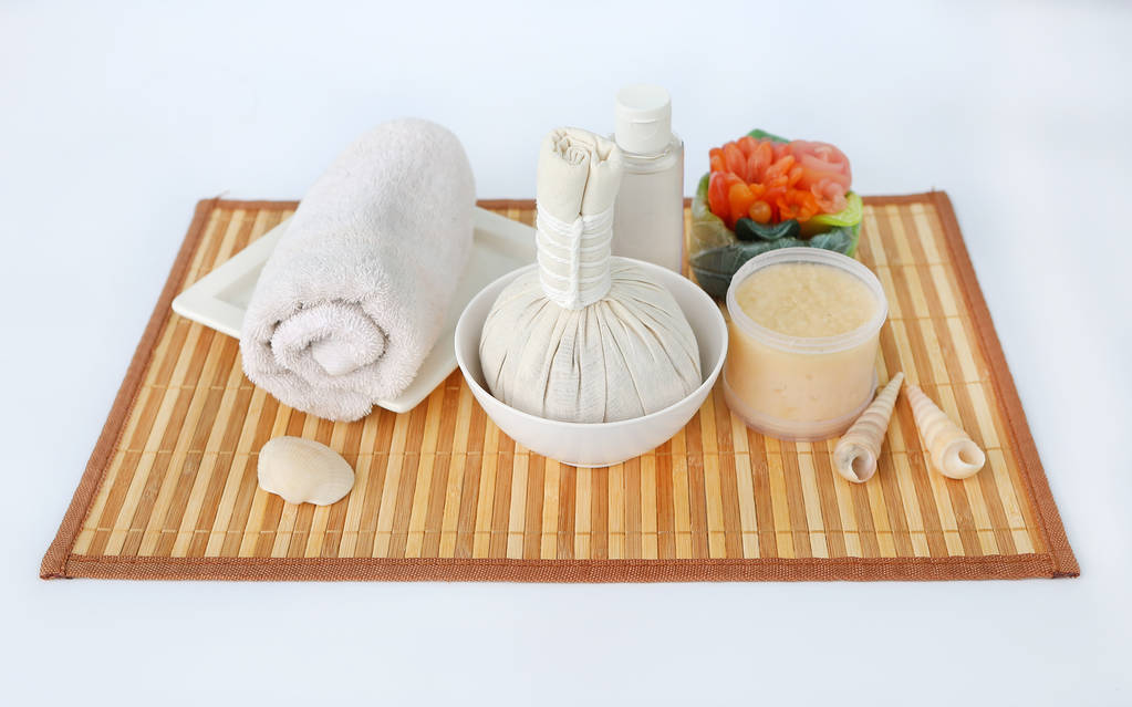 Spa boule compressante à base de plantes avec serviettes et gommage au sel, concept de spa sur panneau de bambou sur fond blanc
 - Photo, image