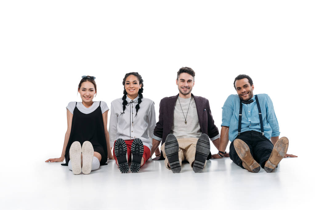 sorridenti amici multietnici seduti sul pavimento
 - Foto, immagini