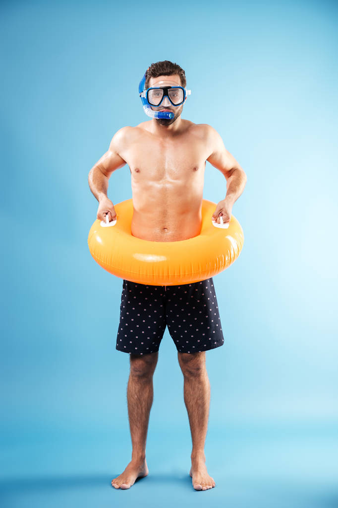 水泳サークルを押しながら孤立した立っている若い男 - 写真・画像
