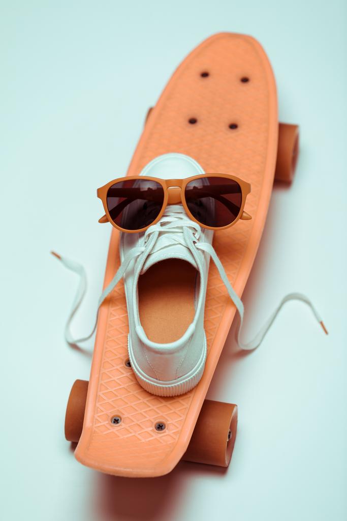 Скейтборд, кроссовки и солнцезащитные очки
 - Фото, изображение