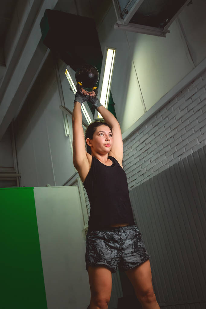 Fitness-Frauentraining mit der Kettlebell. fitte junge Frau beim Crossfit-Training. - Foto, Bild