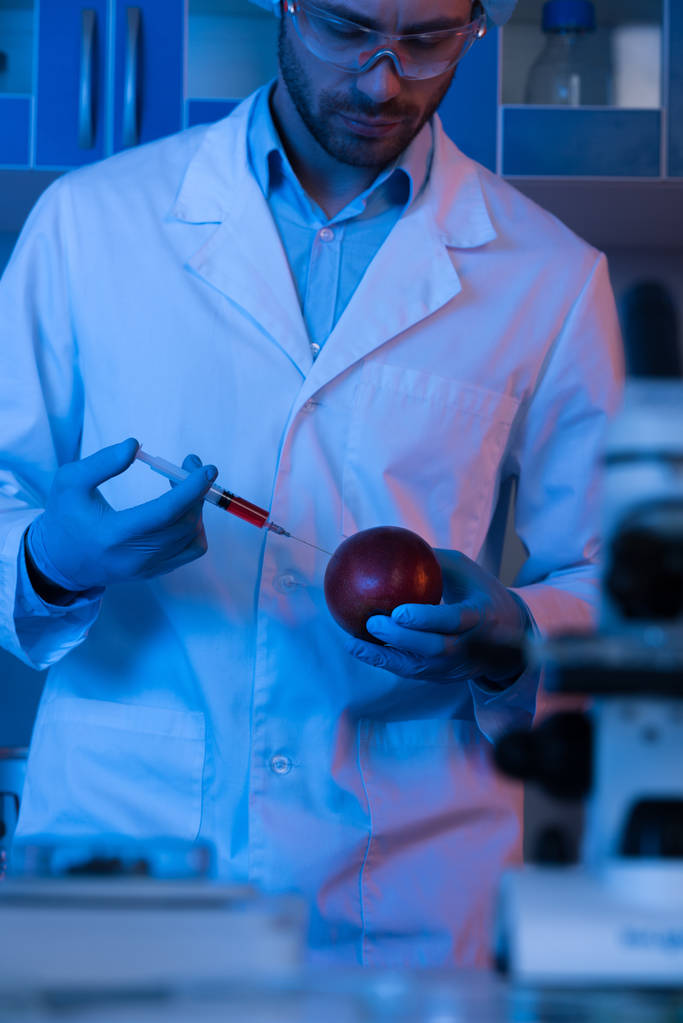 Wissenschaftler mit Spritze und Apfel  - Foto, Bild