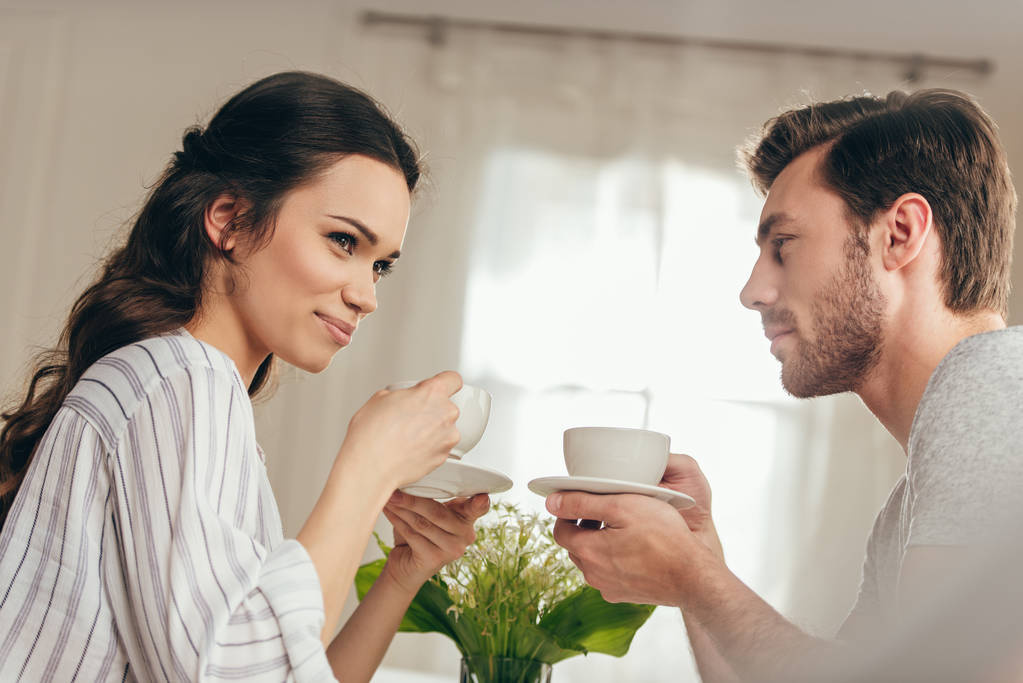 νεαρό ζευγάρι πίνοντας καφέ στο σπίτι - Φωτογραφία, εικόνα