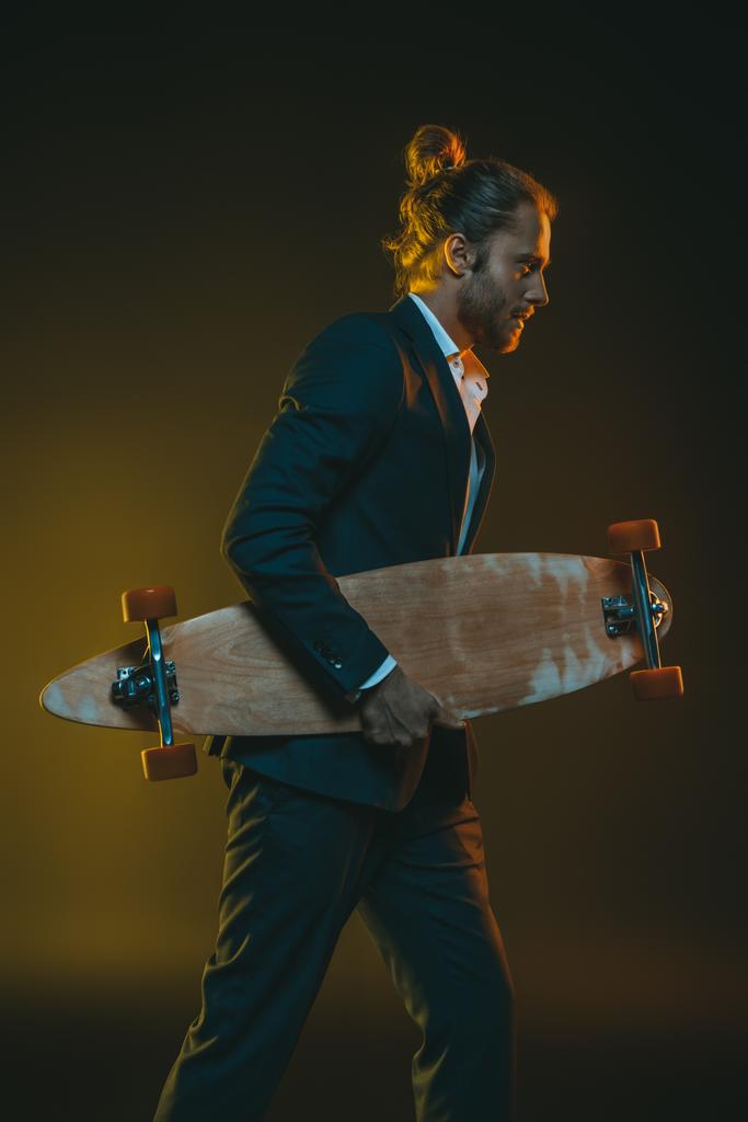 man in smoking met skateboard - Foto, afbeelding
